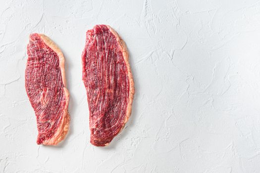 Organic picanha beef meat steaks, over white textured background, top view space for text