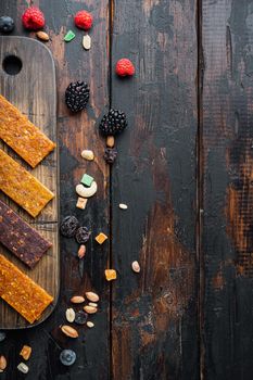 Healthy fitness energy bars with dried fruits and nuts, flat lay with space for text, on wooden table