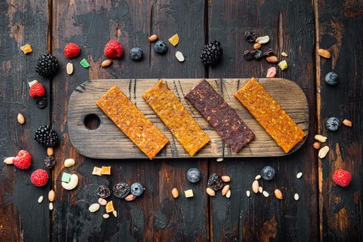 Healthy fitness energy bars with dried fruits and nuts, top view, on wooden table