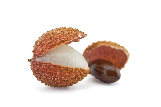 Lychee fruit opened and showing seed isolated on white background