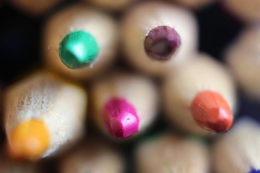 Close-up view of bright colored multicolor pencils on black background