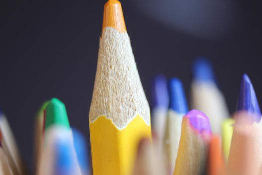 Close-up view of bright colored multicolor pencils on black background