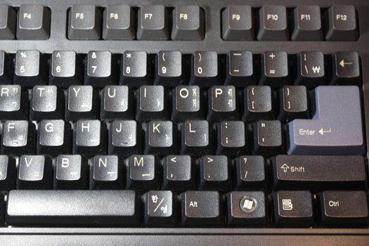 Closeup of laptop computer keyboard black keys with white letters and numbers. Black keys with white characters.