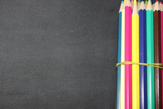 Close-up view of bright colored multicolor pencils on black background