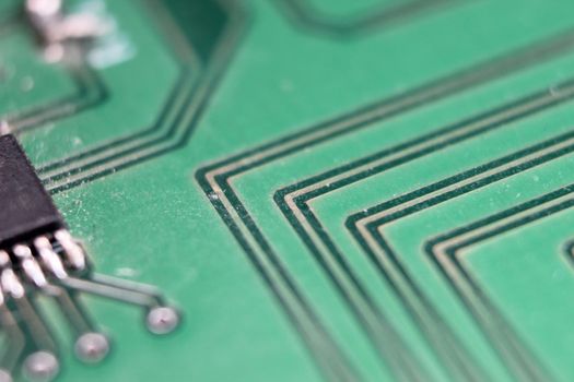 Electronic board with circuit lines and chip. Macro view of green board