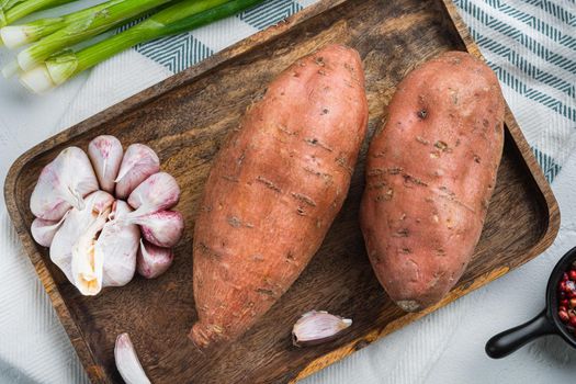 Sweet potato or batat with spices on white background, top view.