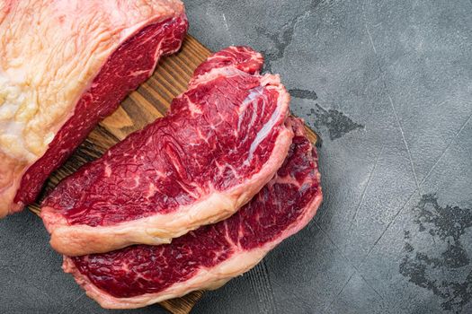 Raw ambassador beef steak cut, on gray background, top view, with copy space for text