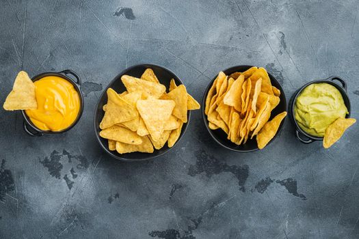 Nachos corn chips with traditional dip sauce set, on gray background, top view or flat lay with copy space for text