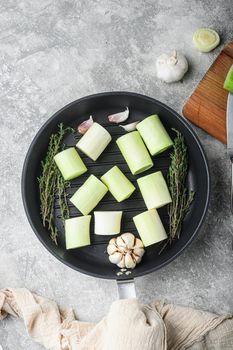 Raw braised Leek sultan on grill pan uncooked with herbs ingredients , on grey textured background top view