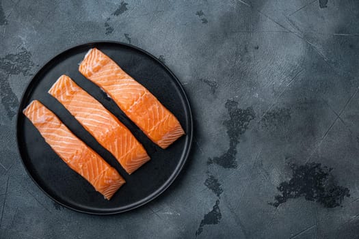 Fresh raw salmon fillet cuts, on grey background, flat lay with space for text