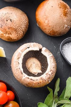 Portabello mushrooms ingredients for baking, cheddar cheese and sage on black background.top view close up