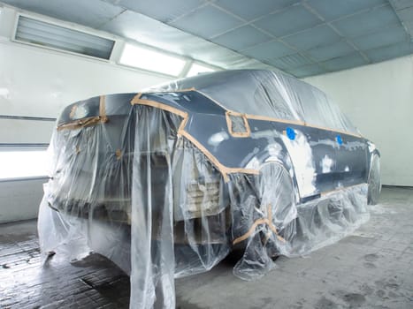car prepared for painting in a spray booth. car putty applied to car parts.