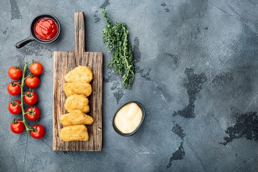 Fried crispy chicken nuggets meat on grey background, top view.