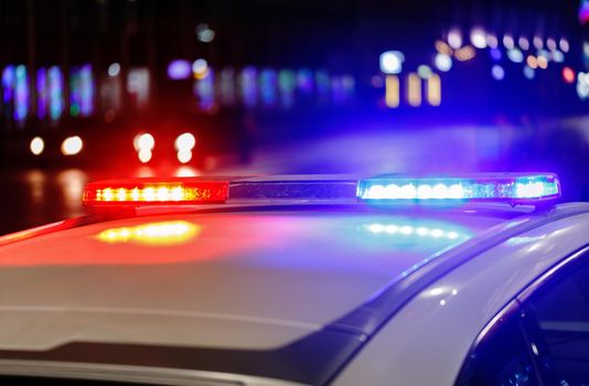police car lights at night in city with selective focus and bokeh blur