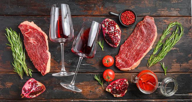 Picanha Center-Cut Steak with glasses of red wine, herbs and pomegranate top view old dark wooden background. Big size