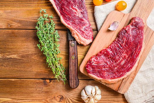 Set of picanha steaks over old american butcher cleaver with seasonings on wooden table. Top view, space for text