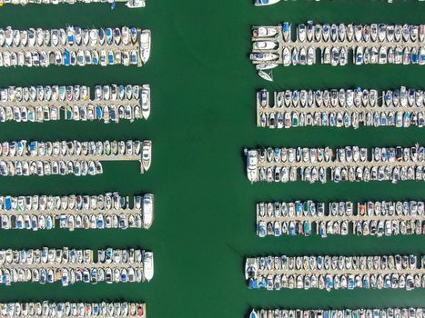 Aerial top view of boats and yachts in marina. Marina lot with yachts, sailboat and speedboat moored at the quay.