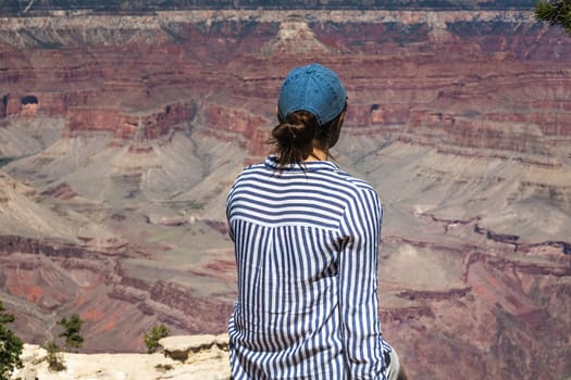 Pretty female enjoys vantage point view on Grand Canyon Arizona, USA.