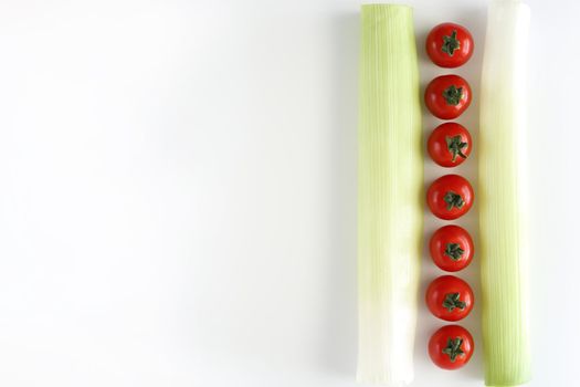 Tomatos with green leek on white background.