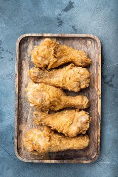 Chicken leg breaded and fried on grey background, flat lay.