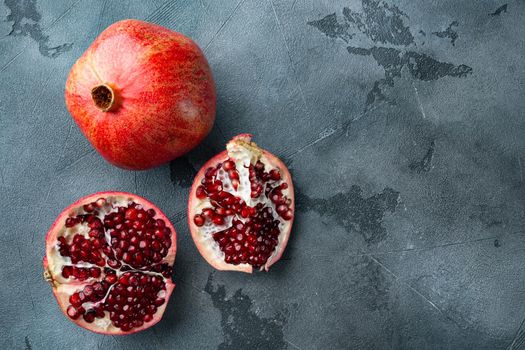 Ripe pomegranate with juicy seeds, on grey background with space for text