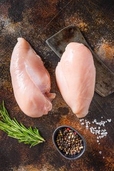 Farm chicken breast fillet, on meat cleaver spices and herbs onold rustic metall table top view