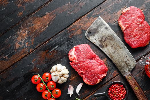 Rump steak organic meat cut, raw marbled beef steak, with old butcher knife cleaver, and seasonings On dark wooden rustic table, top view with space for text