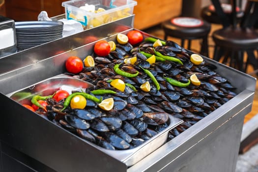 Turkish style appetizer street food stuffed mussels called midye dolma on bench for sale with lemon which is served with a squirt of lemon juice in Istanbul, Turkey.