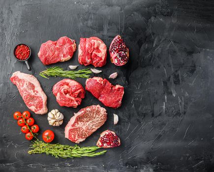 Set of various classic, alternative steaks picanha, ramp and chuck eye rollover black background top view. Big size space for text.