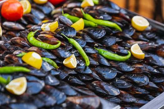 Turkish style appetizer street food stuffed mussels called midye dolma on bench for sale with lemon which is served with a squirt of lemon juice in Istanbul, Turkey.