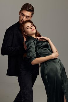 A woman in an evening dress is leaning on the shoulder of a sexy man in a suit. High quality photo