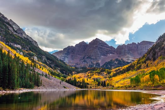 Autumn aspen trees reflected in the lake. Maroon bells at autumn season in in Aspen Colorado, USA.