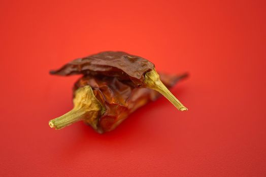 Macro image of dried red chilli pepper on red background