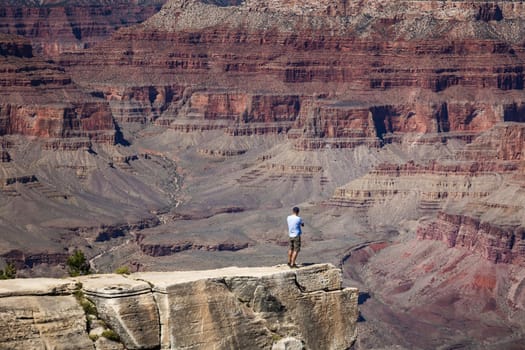 Brave male enjoys vantage point view on Grand Canyon Arizona, USA.