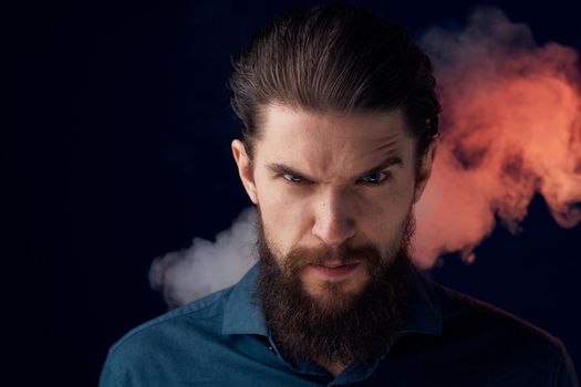 Emotional bearded man angry look shirt smoke in the background. High quality photo