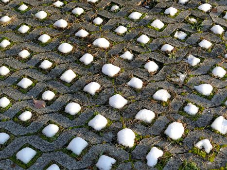 snow caps on grass pavers in winter in Germany