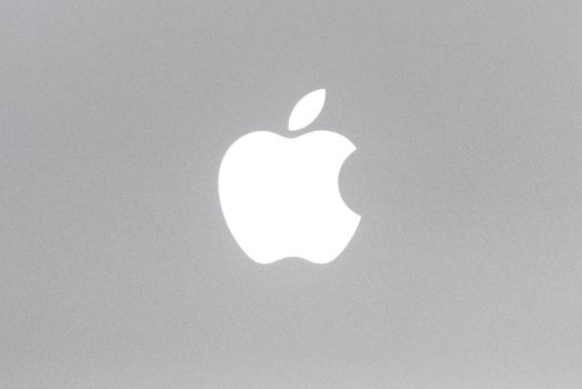 BAYONNE, FRANCE - CIRCA JANUARY 2021: Macro shot of MacBook Pro backlit Apple logo, brushed aluminium texture.