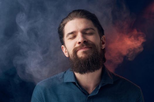 Emotional man black shirt attractive look close-up smoke in the background. High quality photo