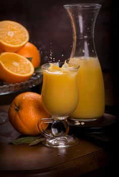 glass of fresh orange juice with fresh fruits on wooden table