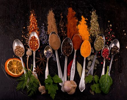 Various spices spoons on stone table. Top view with copy space.