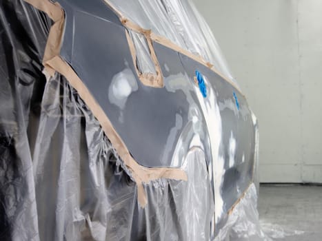 car prepared for painting in a spray booth. car putty applied to car parts.