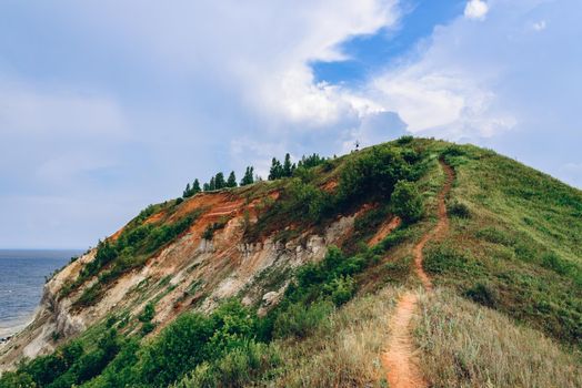 Hiking trail on mountainside at summer cloudy day