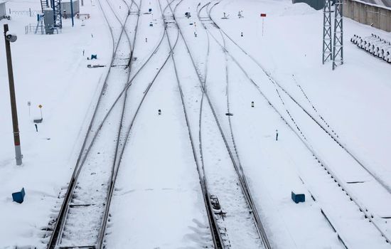 Winter railway road with white snow. Rails in the snow.