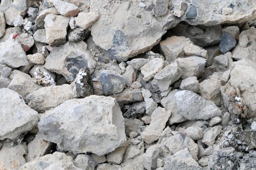 broken concrete floor at building construction site. cracked concrete texture background. Grey surface with cracks close up. A lot of pieces of splintered plaster. Abstract concept of split, dissent,