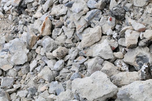 broken concrete floor at building construction site. cracked concrete texture background. Grey surface with cracks close up. A lot of pieces of splintered plaster. Abstract concept of split, dissent,