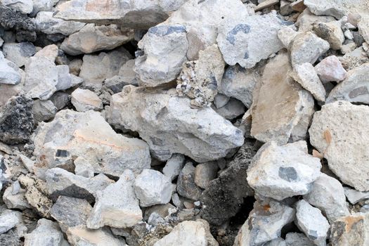 broken concrete floor at building construction site. cracked concrete texture background. Grey surface with cracks close up. A lot of pieces of splintered plaster. Abstract concept of split, dissent,