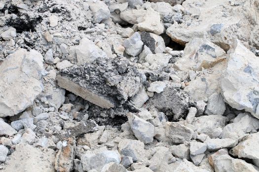 broken concrete floor at building construction site. cracked concrete texture background. Grey surface with cracks close up. A lot of pieces of splintered plaster. Abstract concept of split, dissent,