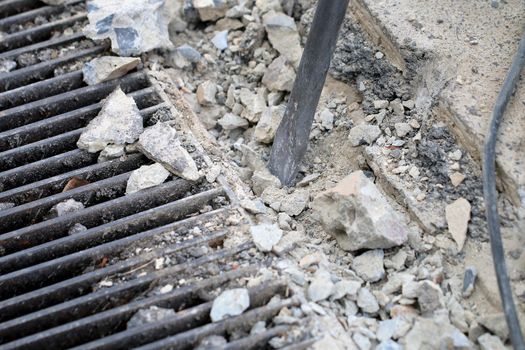 Male workers use electric concrete breaker for digging and drilling concrete repairing driveway surface with jackhammer at the local city road, during sidewalk, work construction site.