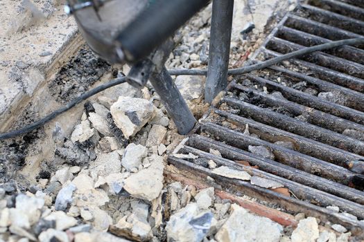 Male workers use electric concrete breaker for digging and drilling concrete repairing driveway surface with jackhammer at the local city road, during sidewalk, work construction site.