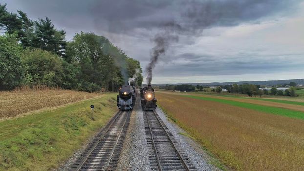 Aerial View of 2 Restored Antique Steam Engines and Passenger Cars Steaming Up at a Small Rail Road Station